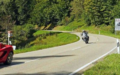 Route de montagne sinueuse avec une moto et des voitures en circulation