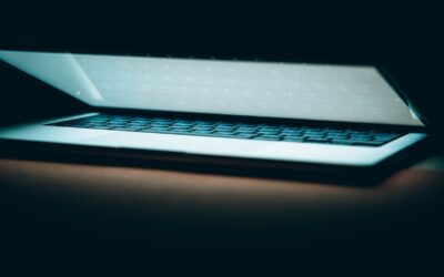 Ordinateur portable ouvert dans l'obscurité, clavier rétroéclairé, écran luminescent