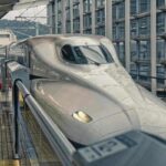 Train de passagers blanc brillant en gare, voyageur sur le quai