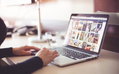 Une personne utilise un ordinateur portable affichant des images sur une table