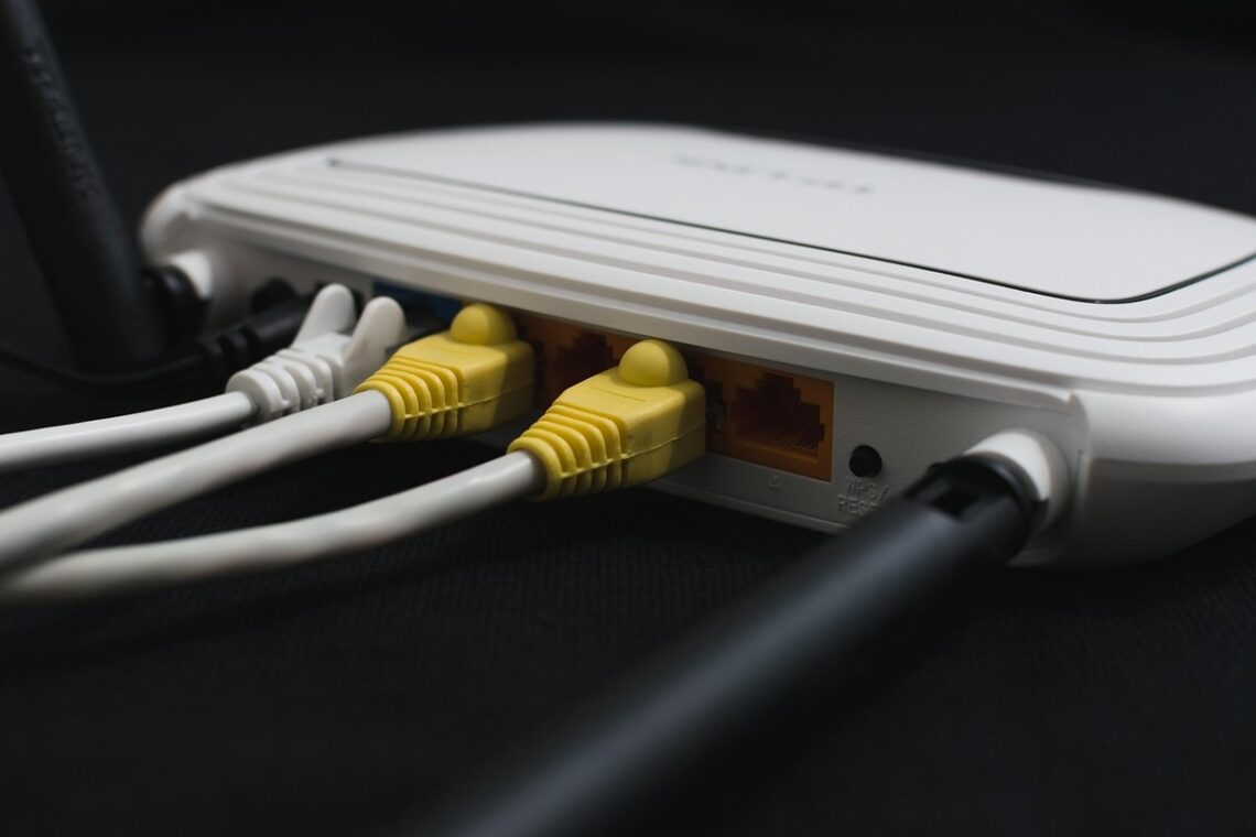 Un routeur Wi‑Fi avec trois câbles Ethernet connectés aux ports jaunes