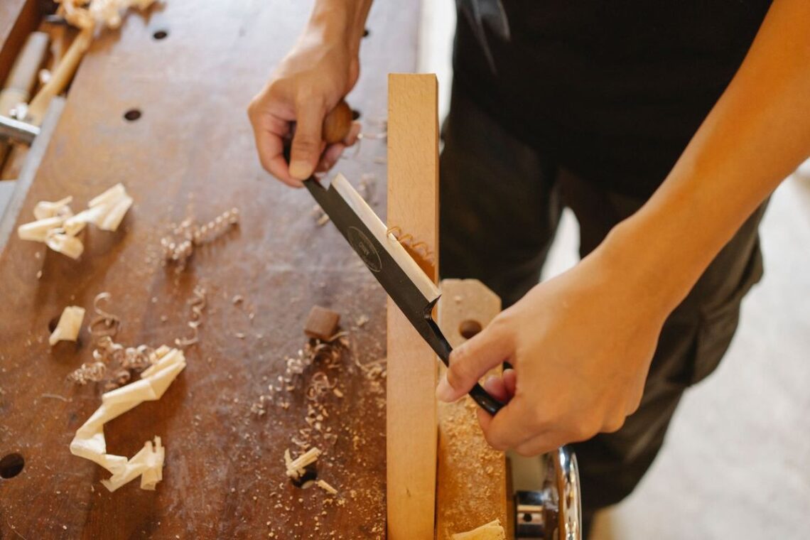 Scie d'une planche sur une table en bois, copeaux et morceaux de bois dispersés