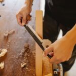 Scie d'une planche sur une table en bois, copeaux et morceaux de bois dispersés