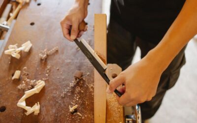 Scie d'une planche sur une table en bois, copeaux et morceaux de bois dispersés