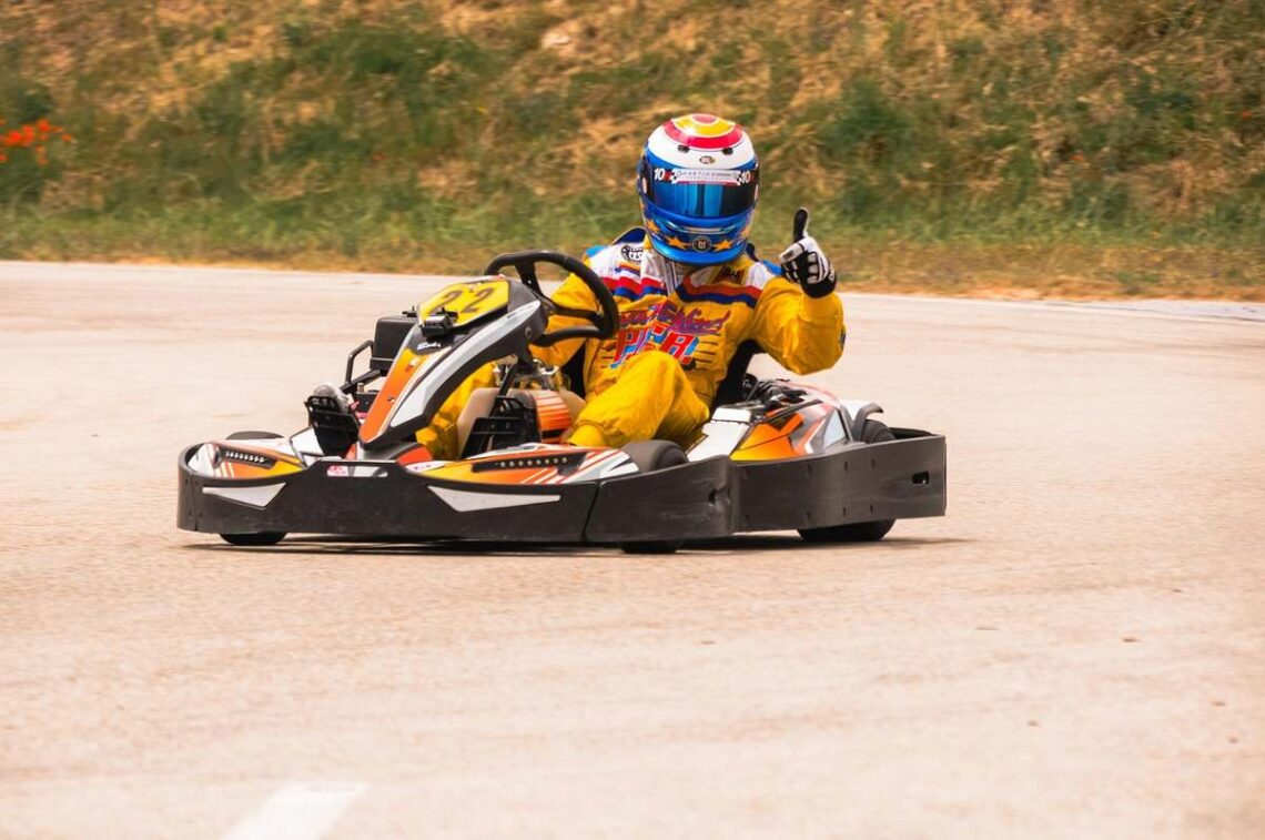Conducteur de kart donne le pouce levé sur piste